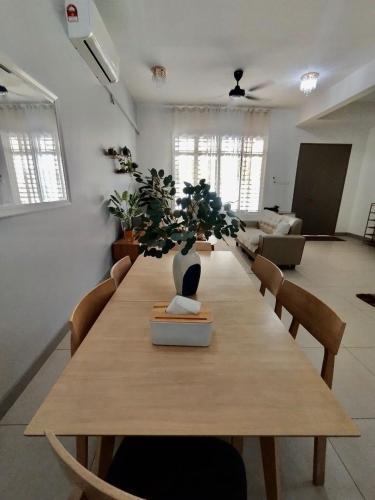 a long wooden table with a vase on top of it at Dedaun Homestay Batu Pahat in Batu Pahat