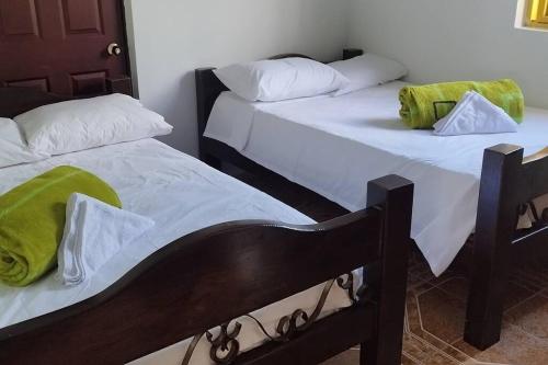 two beds sitting next to each other in a room at Finca en el Quindío - Arrullo Cafetero in Quimbaya