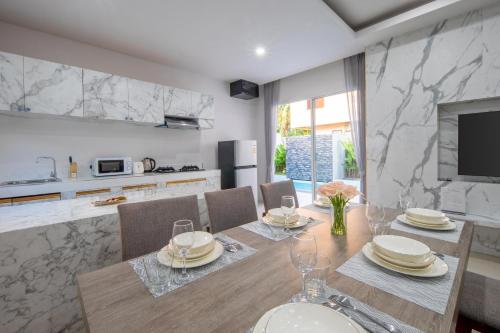 a kitchen and dining room with a table and chairs at Sasi Pool Villa Phuket in Rawai Beach