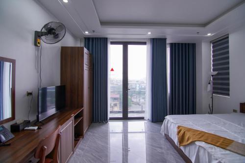 a bedroom with a bed and a flat screen tv at GOLDEN JOY HOTEL & APARTMENT in Hai Phong