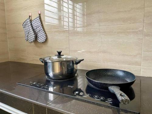 a pot on a stove with a pan on it at Cozy Sunny Home BBQ Steamboat KTV Bukit Indah JB in Johor Bahru