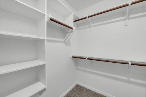 a white walk in closet with white shelves at Luxury Retreat in Serene Surroundings, 4 Bedrooms Corporate House, Entire house with full amanities, Convenient location Near Medical Centers and Downtown in Temple