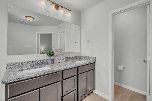 a bathroom with two sinks and a mirror at Luxury Retreat in Serene Surroundings, 4 Bedrooms Corporate House, Entire house with full amanities, Convenient location Near Medical Centers and Downtown in Temple