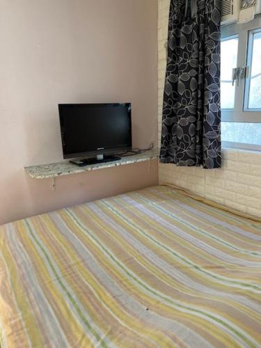 a bedroom with a flat screen tv and a bed at Sea View Holiday House in Hong Kong