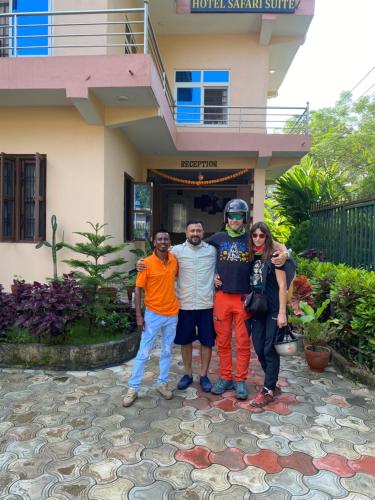 a group of people standing in front of a house at Hotel Safari Suite in Sauraha