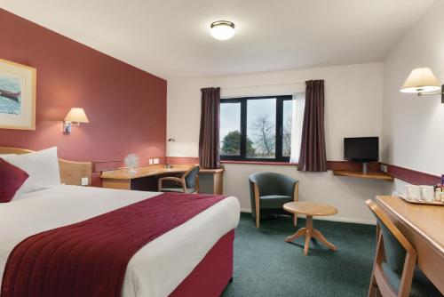 Days Inn Hotel Abington - Glasgow في أبينغتون: غرفة في الفندق مع سرير ومكتب