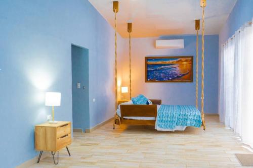 a bedroom with a swing bed and blue walls at Rancho Plèyades in Metalío