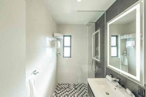 a white bathroom with a sink and a mirror at Ameritania at Times Square in New York