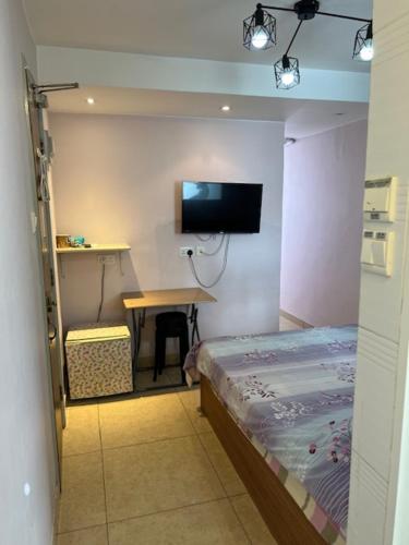 a room with a bed and a table and a tv at Sea View Holiday House in Hong Kong