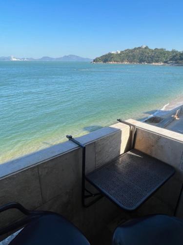 a balcony with a table and chairs overlooking the ocean at Sea View Holiday House in Hong Kong