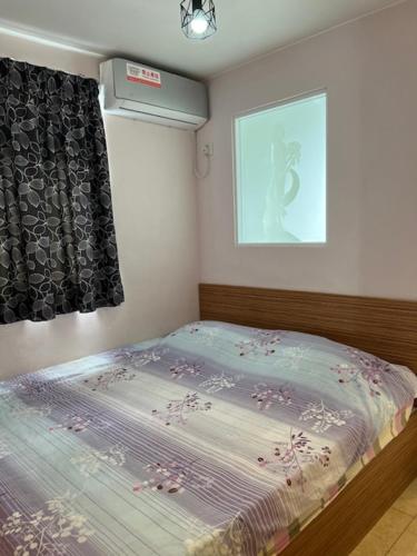 a small bedroom with a bed with a window at Sea View Holiday House in Hong Kong