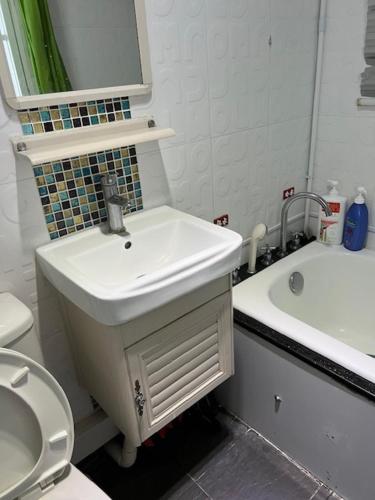 a white bathroom with a sink and a toilet at Sea View Holiday House in Hong Kong