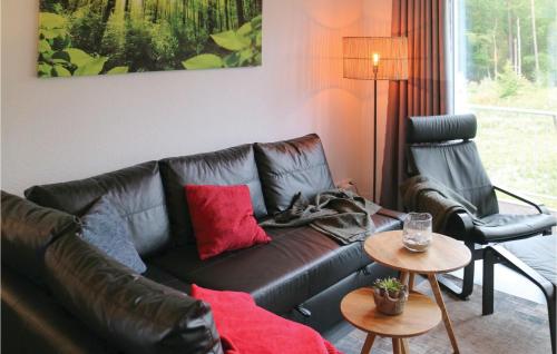 sala de estar con sofá de cuero y silla en Lovely Apartment In Graal Müritz, en Graal-Müritz
