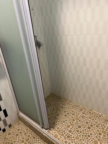a bathroom with a shower with a tiled floor at Sea View Holiday House in Hong Kong