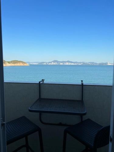 a balcony with two benches and a view of the ocean at Sea View Holiday House in Hong Kong