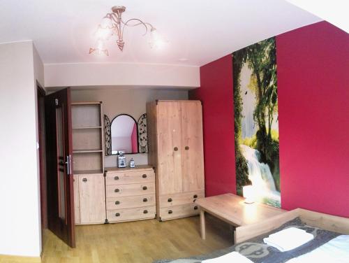 a bedroom with pink walls and a dresser at Willa Jula in Białystok