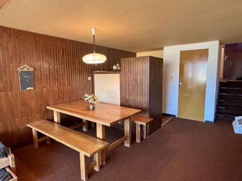 une salle à manger avec une table et des bancs en bois dans l'établissement Studio 6 pers, 52m², skis aux pieds, parking, Alpe d'Huez - FR-1-405-364, à Huez