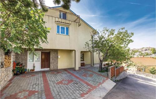 a house with a driveway in front of it at Lovely Apartment In Sveti Juraj in Sveti Juraj