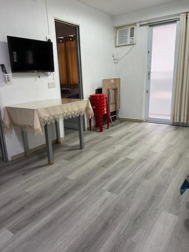 a room with a table and a tv on a wall at Sea View Holiday House in Hong Kong