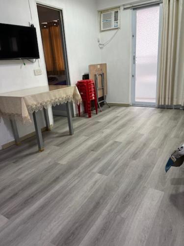 a living room with a wooden floor and a television at Sea View Holiday House in Hong Kong