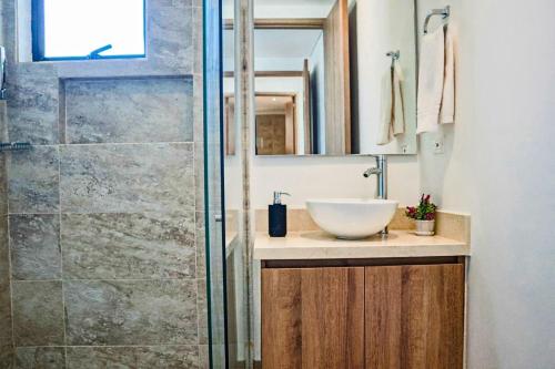 Un baño con lavabo y ducha de cristal. en Dizztravel Apart Murano Centro Exclusivo apto 2701, en Cartagena de Indias