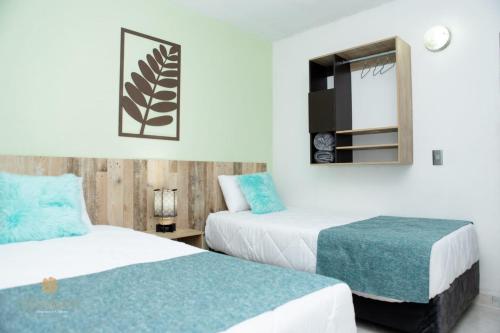 a hotel room with two beds and a mirror at ArisSha Boutique Hotel in Cali