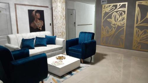 a living room with a couch and blue chairs at ArisSha Boutique Hotel in Cali