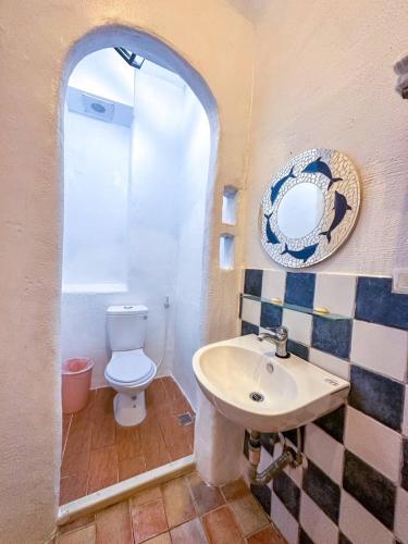 a bathroom with a white toilet and a sink at Rockhand Homestay in Eluan
