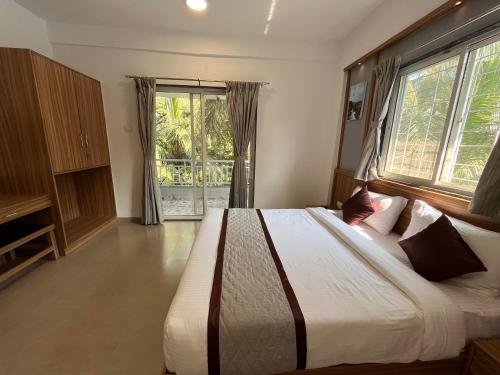 a bedroom with a large bed and a large window at Hotel Suryaprabha- Near Diveagar Beach in Diveagar