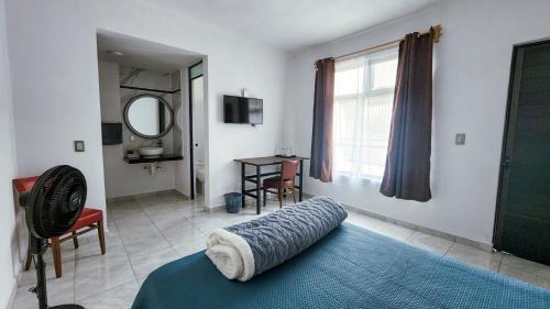 a bedroom with a bed and a mirror and a window at La Palma Coliving in San Lucas Xoloc