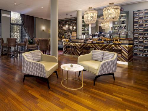 a restaurant with two chairs and a table and a bar at Hotel Indigo Turin by IHG in Turin