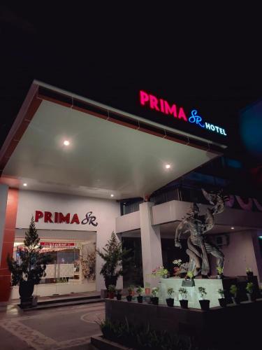 a pima gas station with a statue in front of it at Prima SR Hotel & Convention Yogyakarta in Yogyakarta
