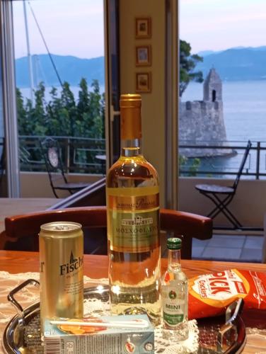 a bottle of whiskey on a table with a view at Casa da Sogno Elegant Studio in Nafpaktos