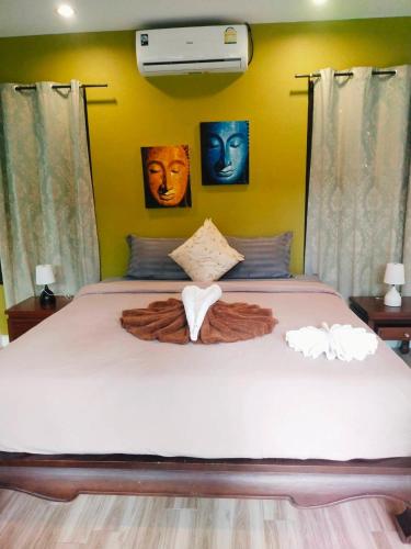 Un dormitorio con una gran cama blanca con una manta. en Villa Chaya, en Khao Lak