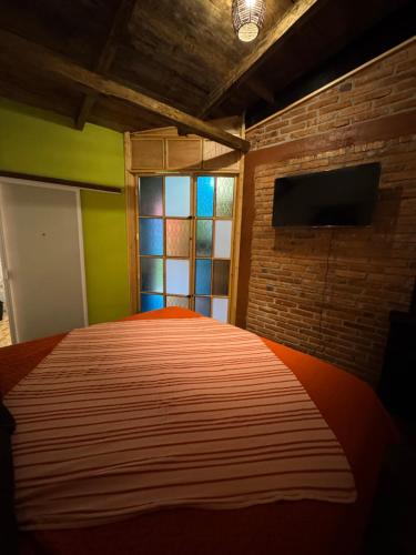 a bedroom with a bed and a brick wall at Rincón del Ángel in Zacatlán