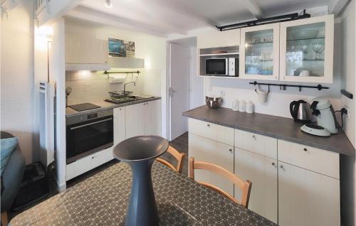 une cuisine avec des armoires blanches et une table avec des chaises dans l'établissement Amazing Home In Agde With Wifi, au Cap d'Agde