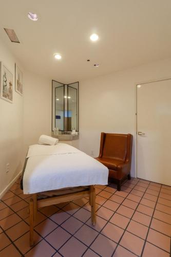 a bedroom with a bed and a chair and a mirror at Camino Real Aeropuerto in Mexico City