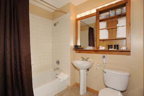 a bathroom with a toilet and a sink and a tub at River Run Village by Keystone Resort in Keystone