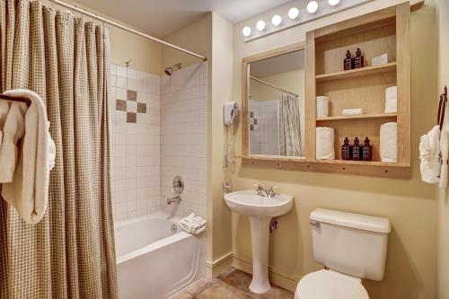 a bathroom with a toilet and a sink and a tub at River Run Village by Keystone Resort in Keystone