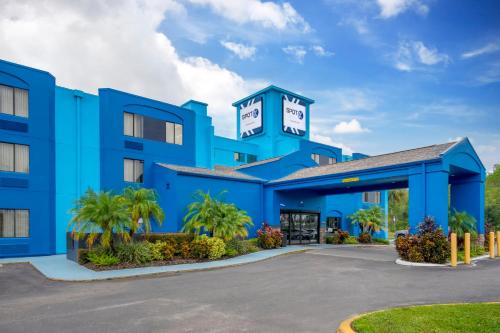 a blue hotel with a parking lot at SPOT X Hotel Tampa - Wesley Chapel by The Red Collection in Wesley Chapel
