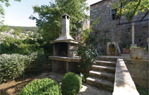 a stone fireplace in the yard of a house at Three-Bedroom Holiday Home In Blato in Blato