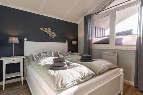 a bedroom with a large bed with pillows on it at Ferienhaus Robbi ⇒ Urlaub am Meer in Wesselburenerkoog