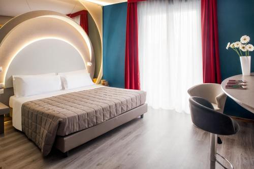 a bedroom with a bed and a table with chairs at Hotel Da Vinci in Milan