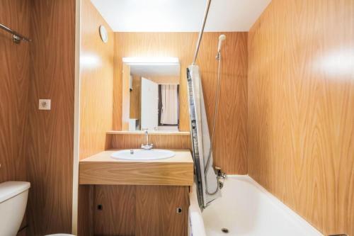 une salle de bain avec un lavabo, une baignoire et des toilettes dans l'établissement Résidence Andromède - maeva Home - Appartement 2 pièces 6 personnes - Budget MAE-3648, à Flaine