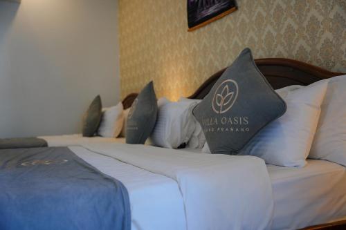 a hotel room with two beds with pillows on them at Villa Oasis in Luang Prabang