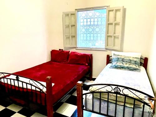 a small room with a bed and a window at Spacious Apartment with Motorcycle Garage, Free Parking, and Air Conditioning in Er Rachidia