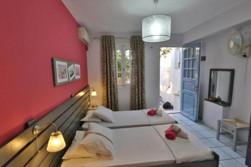 a bedroom with two beds and a red wall at Kini Bay in Kinion