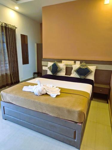 a hotel room with a bed with towels on it at Alfa Inn in Nedumbassery
