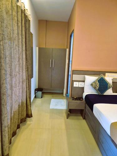 a bedroom with a bed and a cabinet in it at Alfa Inn in Nedumbassery