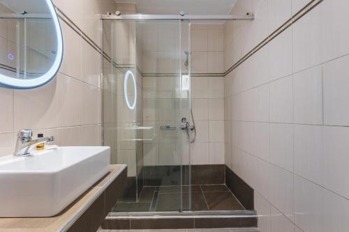 a bathroom with a sink and a shower at Yakinthos Hotel in Laganas